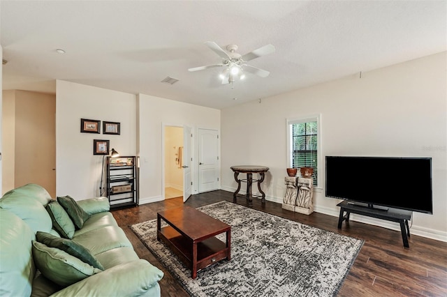 living area with a ceiling fan, dark wood finished floors, and baseboards