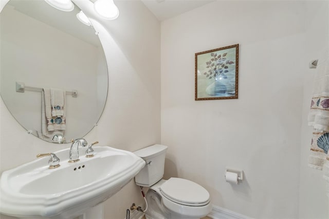 half bathroom featuring a sink and toilet