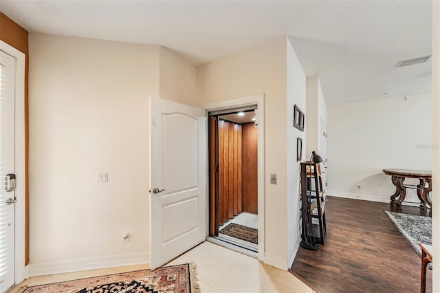 foyer entrance featuring light wood-style flooring and baseboards