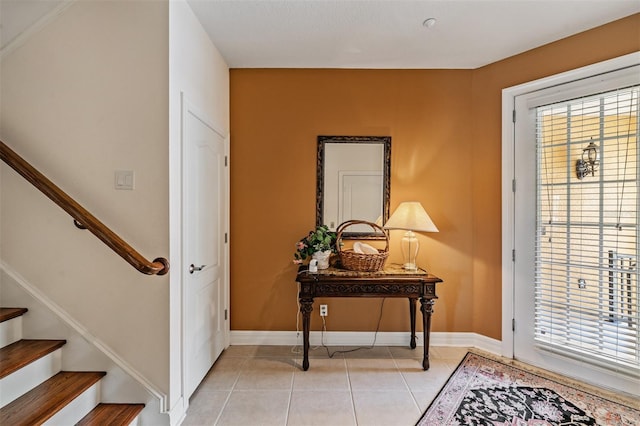 entrance foyer with stairway, plenty of natural light, light tile patterned floors, and baseboards