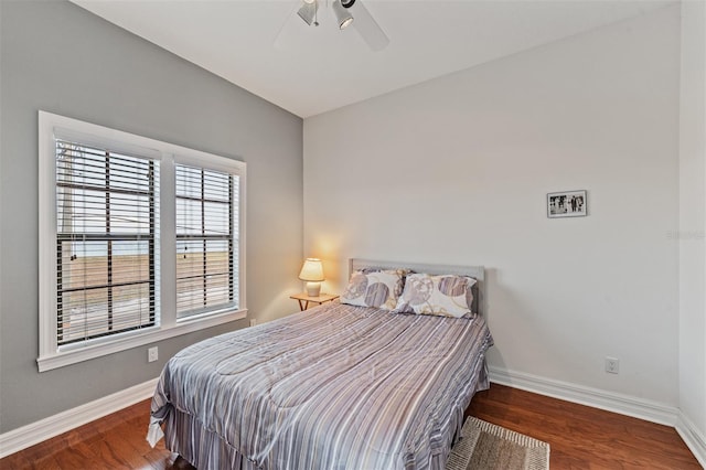 bedroom featuring baseboards, wood finished floors, and ceiling fan