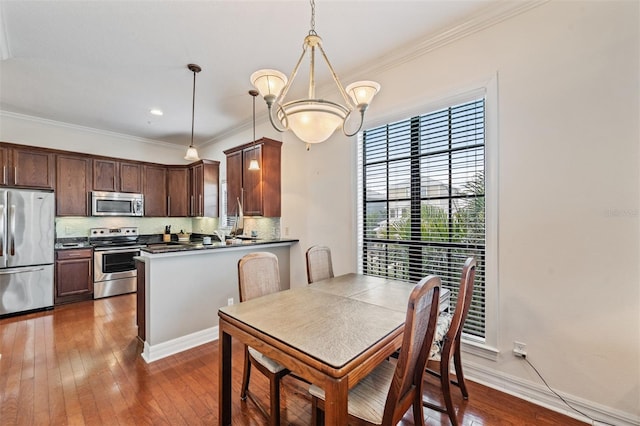 dining area with crown molding, dark wood-type flooring, and baseboards