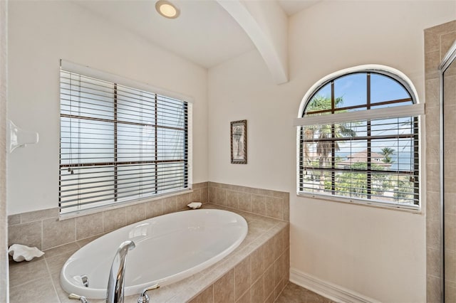 full bathroom with a garden tub and beamed ceiling