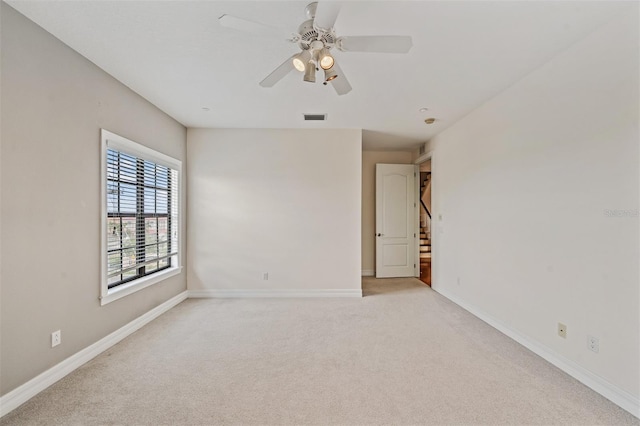 empty room with light carpet, ceiling fan, and baseboards