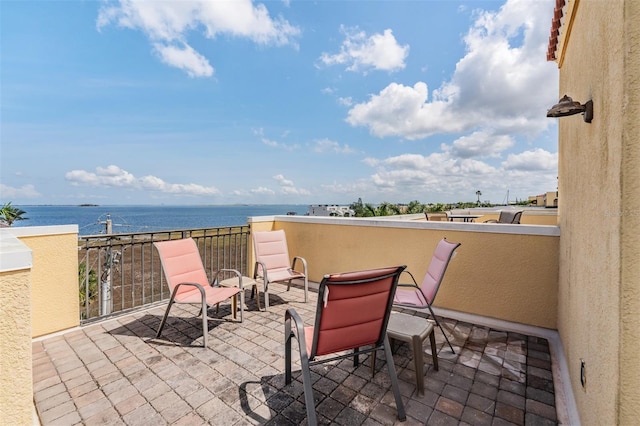 view of patio / terrace with a water view and a balcony