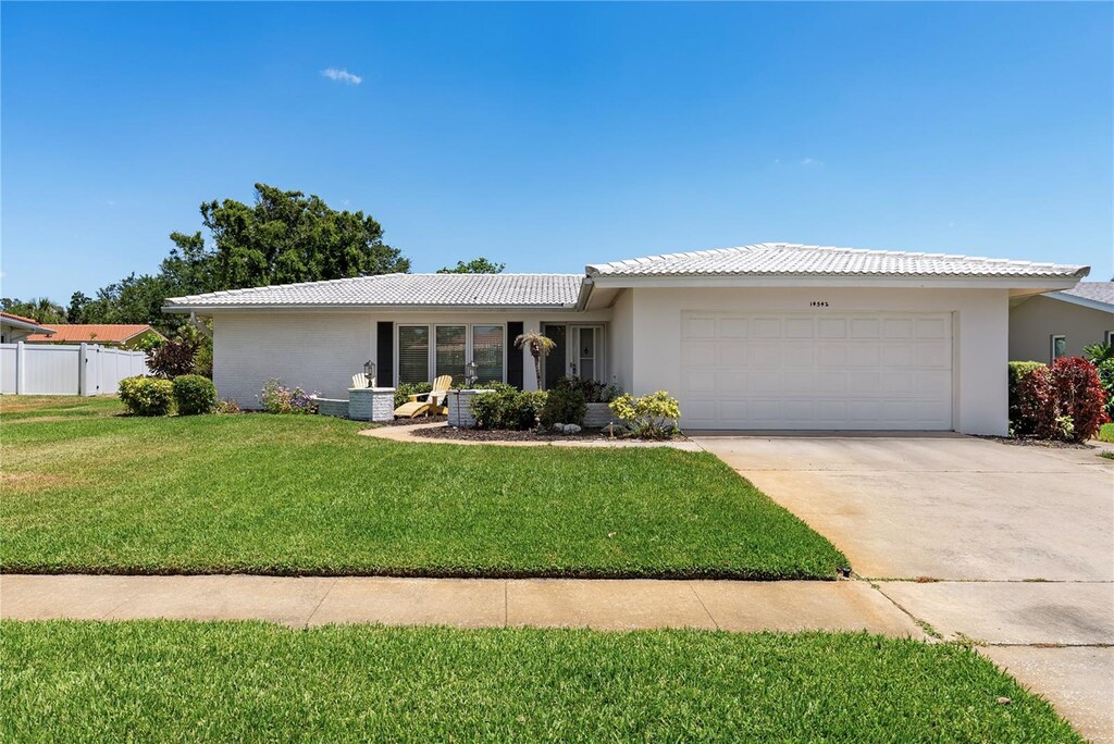 14542 Anchorage Cir, Seminole, FL 33776 - ranch-style house featuring a garage, concrete driveway, stucco siding, and a tiled roof