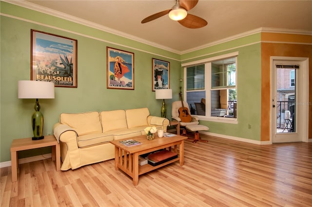 living room with light wood finished floors, baseboards, ceiling fan, and crown molding