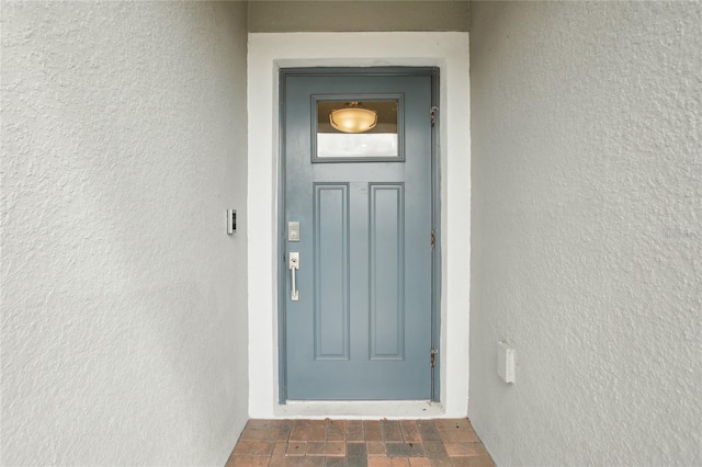 entrance to property featuring stucco siding