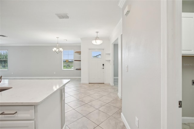 kitchen with white cabinets, visible vents, ornamental molding, and a healthy amount of sunlight