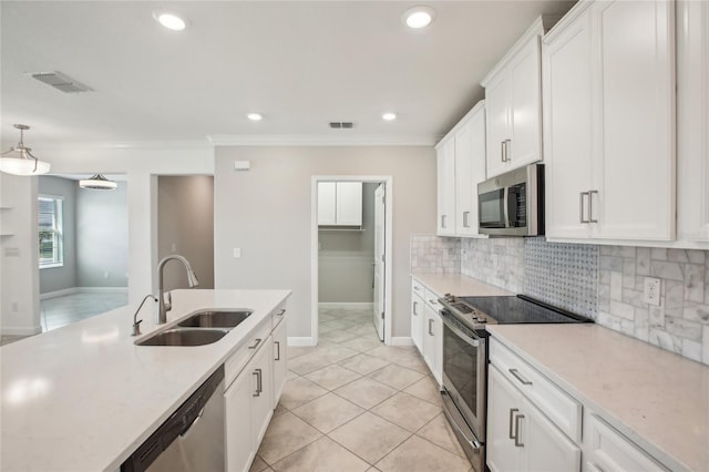 kitchen with appliances with stainless steel finishes, a sink, white cabinetry, tasteful backsplash, and visible vents
