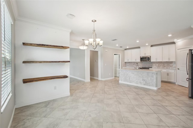 kitchen with an inviting chandelier, appliances with stainless steel finishes, ornamental molding, and backsplash