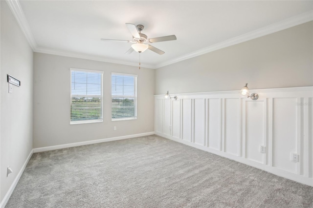 carpeted spare room featuring crown molding, ceiling fan, and baseboards
