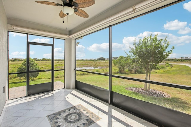 unfurnished sunroom with a water view and ceiling fan