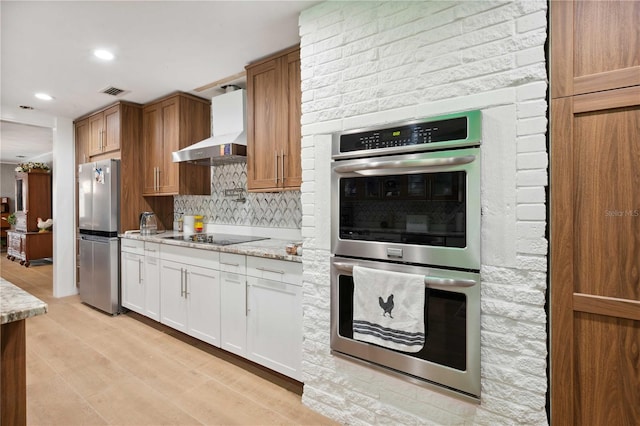 36601 Roberts Rd, Dade City, FL 33525 - kitchen with wall chimney range hood, light stone countertops, stainless steel appliances, tasteful backsplash, and visible vents