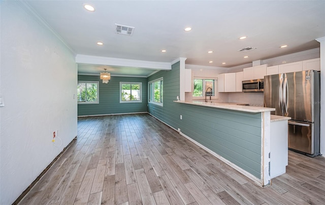 kitchen featuring visible vents, crown molding, appliances with stainless steel finishes, and light wood-type flooring