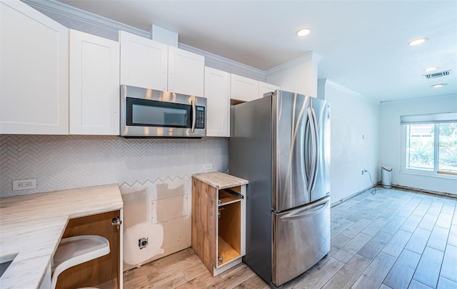 kitchen featuring light wood-style flooring, stainless steel appliances, white cabinetry, tasteful backsplash, and visible vents
