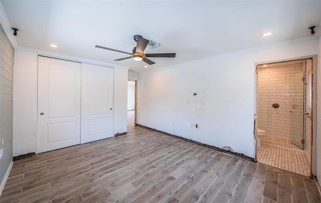 unfurnished bedroom with crown molding, ceiling fan, wood finished floors, ensuite bathroom, and a closet
