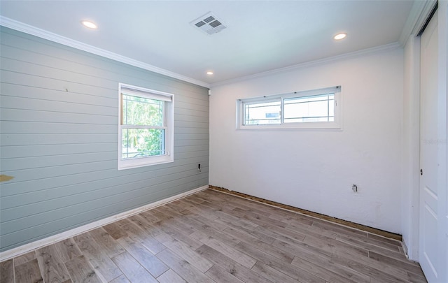 empty room with visible vents, recessed lighting, light wood-style floors, and crown molding