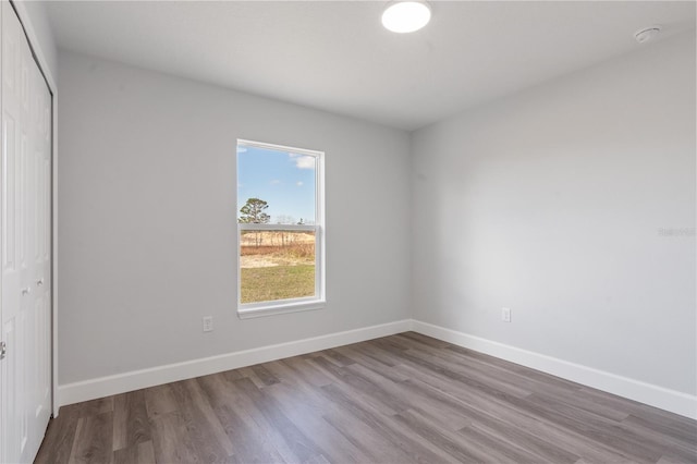 unfurnished room with baseboards and wood finished floors
