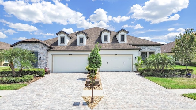 4300 Barletta Ct, Wesley Chapel, FL 33543 - view of front of property with decorative driveway, an attached garage, stucco siding, stone siding, and a shingled roof