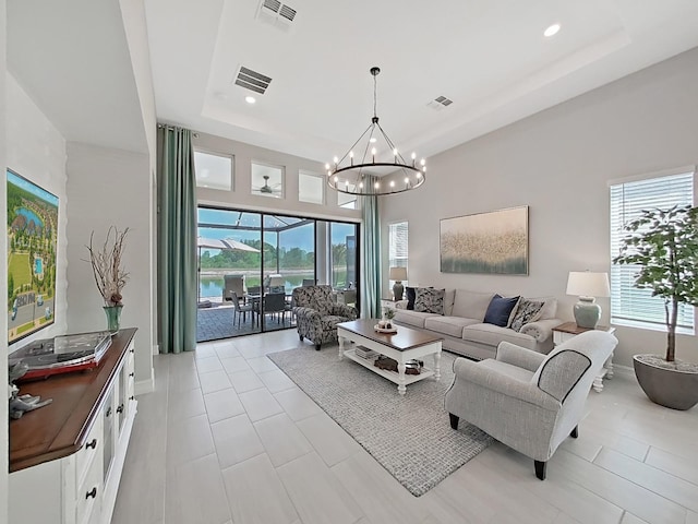 4300 Barletta Ct, Wesley Chapel, FL 33543 - living room with plenty of natural light, a raised ceiling, a chandelier, baseboards, and recessed lighting