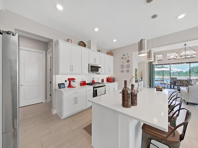 4300 Barletta Ct, Wesley Chapel, FL 33543 - kitchen with appliances with stainless steel finishes, a kitchen bar, light countertops, a sink, and backsplash