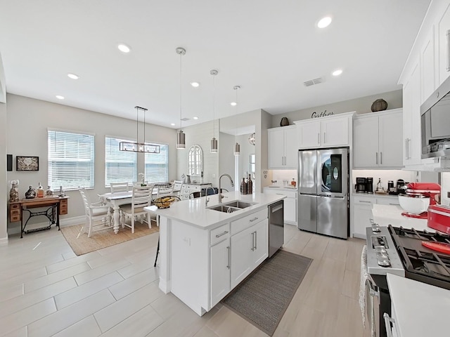 4300 Barletta Ct, Wesley Chapel, FL 33543 - kitchen with appliances with stainless steel finishes, a sink, light countertops, white cabinetry, and recessed lighting