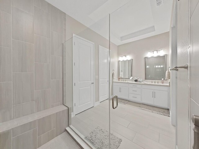 4300 Barletta Ct, Wesley Chapel, FL 33543 - bathroom with double vanity, tiled shower, a raised ceiling, and tile patterned floors