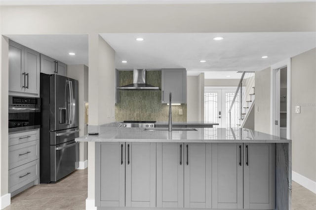 105 E Davis Blvd Unit A, Tampa, FL 33606 - kitchen featuring wall chimney range hood, appliances with stainless steel finishes, gray cabinets, baseboards, and backsplash