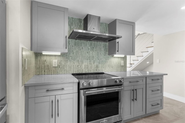 105 E Davis Blvd Unit A, Tampa, FL 33606 - kitchen with wall chimney range hood, stainless steel range with electric cooktop, gray cabinetry, and backsplash