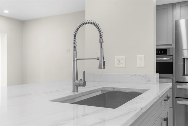 105 E Davis Blvd Unit A, Tampa, FL 33606 - kitchen with light stone counters, a sink, gray cabinets, and stainless steel appliances