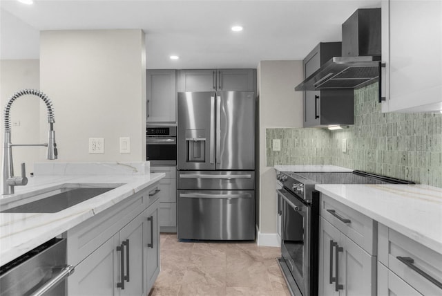 105 E Davis Blvd Unit A, Tampa, FL 33606 - kitchen with gray cabinets, appliances with stainless steel finishes, a sink, light stone counters, and wall chimney exhaust hood