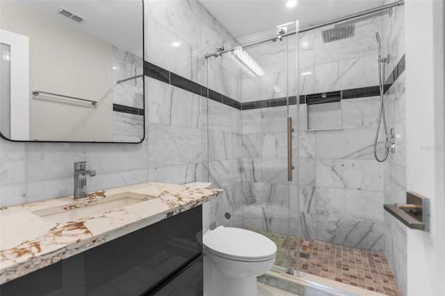 105 E Davis Blvd Unit A, Tampa, FL 33606 - bathroom with visible vents, tile walls, vanity, toilet, and a marble finish shower