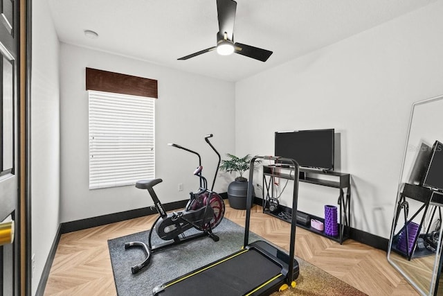 workout area featuring ceiling fan and baseboards