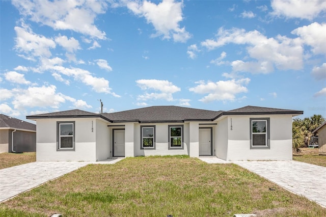 prairie-style home with stucco siding and a front yard