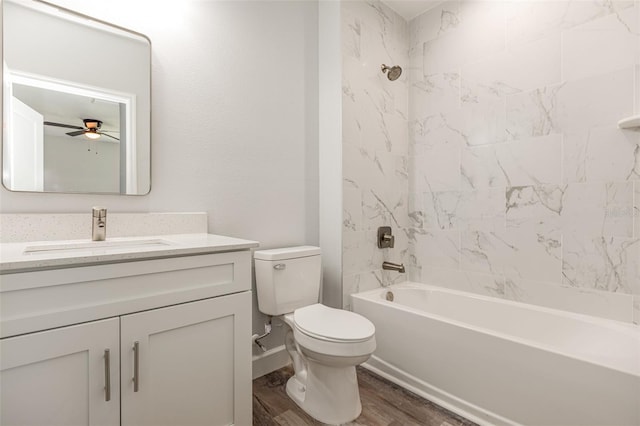 bathroom with ceiling fan, shower / bathing tub combination, wood finished floors, vanity, and toilet