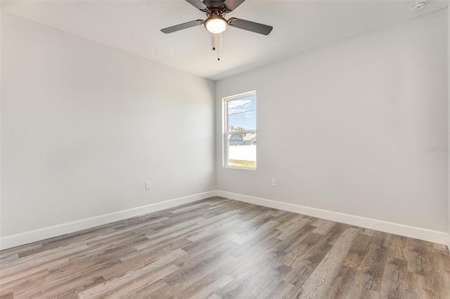 empty room with baseboards, ceiling fan, and wood finished floors
