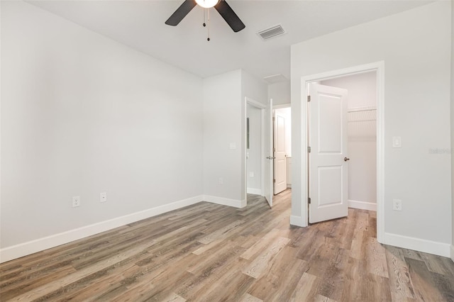 unfurnished bedroom with visible vents, a ceiling fan, light wood finished floors, and baseboards