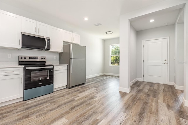 kitchen with light countertops, stainless steel appliances, and white cabinetry