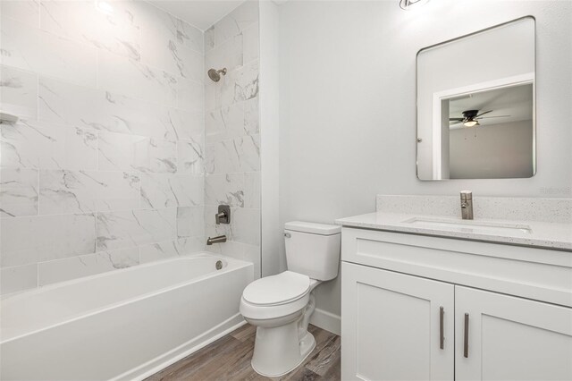full bathroom featuring vanity, wood finished floors, toilet, ceiling fan, and shower / bathing tub combination