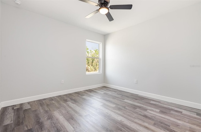 empty room with baseboards, ceiling fan, and wood finished floors