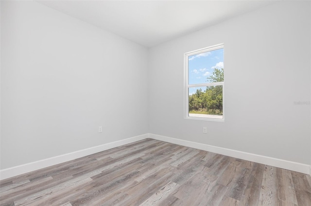 unfurnished room with baseboards and wood finished floors