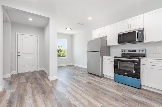 kitchen with appliances with stainless steel finishes, light wood-type flooring, light countertops, baseboards, and white cabinets