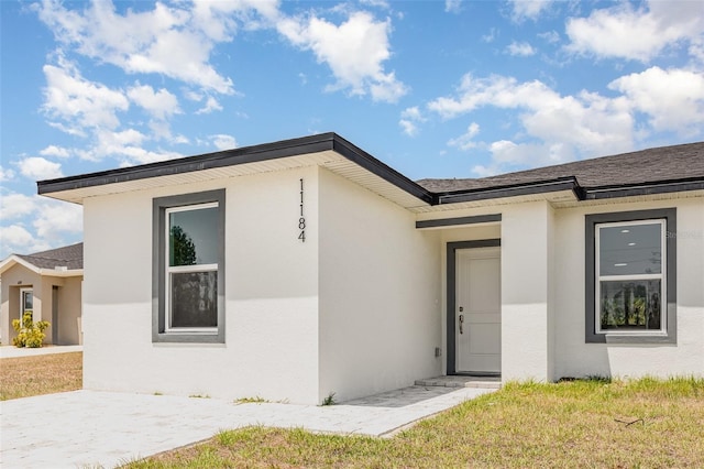 view of front of house with a front lawn and stucco siding