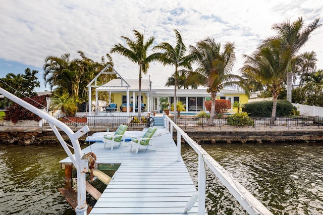 2487 W Bay Isle Dr SE, Saint Petersburg, FL 33705 - dock area with fence, a patio, a water view, and boat lift