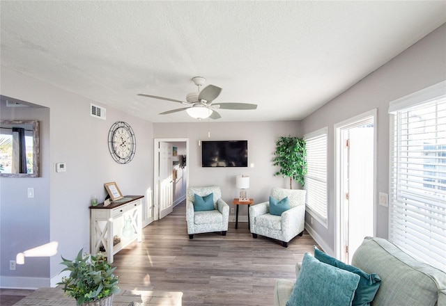 living area featuring a healthy amount of sunlight, baseboards, and visible vents