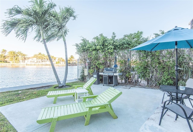 view of patio / terrace with outdoor dining area, a water view, and grilling area