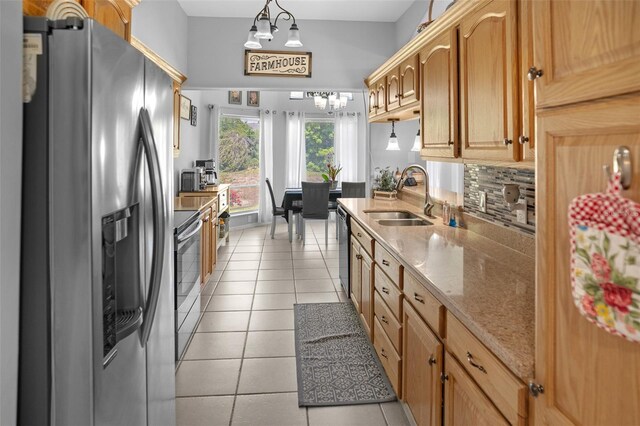 8712 Ashbury Dr, Hudson, FL 34667 - kitchen with appliances with stainless steel finishes, light stone counters, a sink, decorative backsplash, and light tile patterned floors