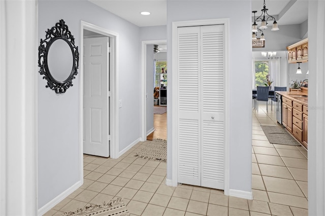 8712 Ashbury Dr, Hudson, FL 34667 - hall with light tile patterned flooring, baseboards, a notable chandelier, and recessed lighting