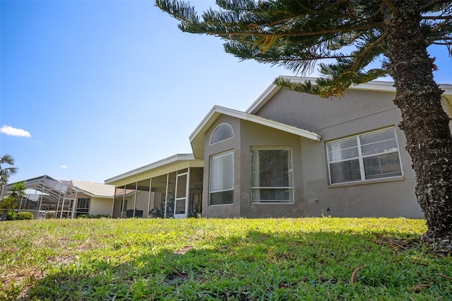 8712 Ashbury Dr, Hudson, FL 34667 - back of house featuring stucco siding and a sunroom